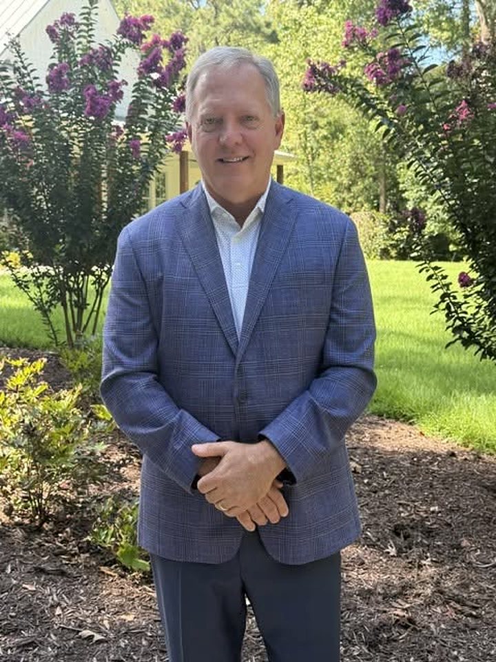 Scott Allison in a blue sport coat, standing in a garden