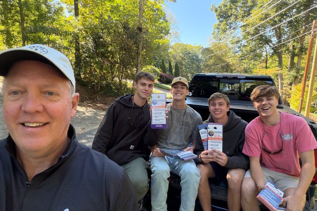 Scott Allison with four young men holding campaign door hangers in the back of a pickup truck